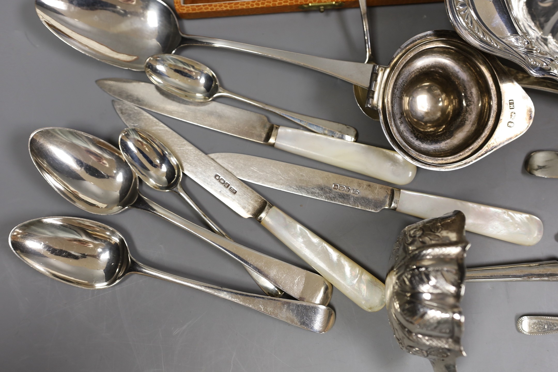 An Edwardian repousse silver oval dish, Birmingham, 1904, 22.8cm, a small quantity of assorted silver flatware including 18th and 19th century pairs of sugar nips, an 18th century silver toddy ladle, white metal cream ju